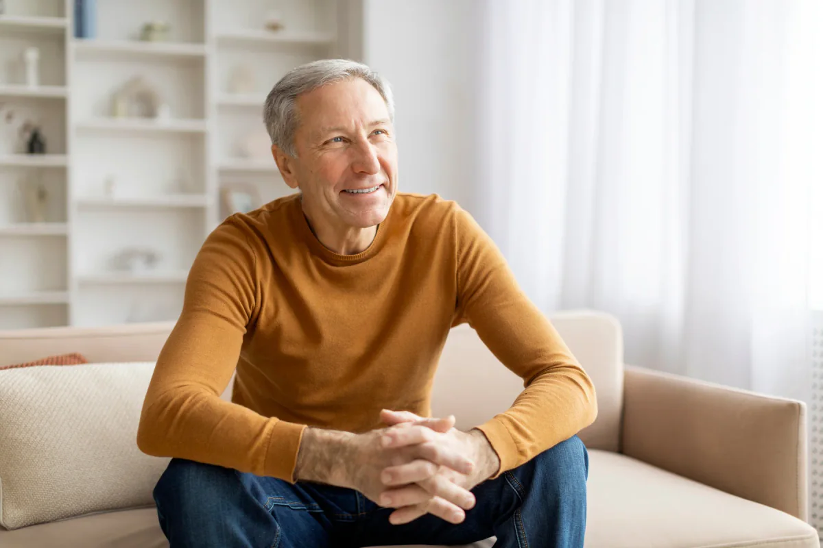 Smiling older man seated comfortably at home