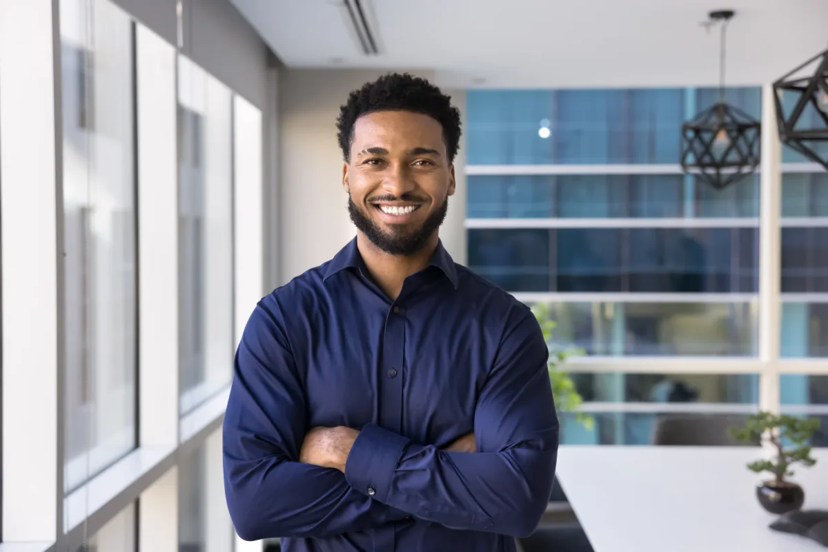 Smiling man standing in a bright, modern office